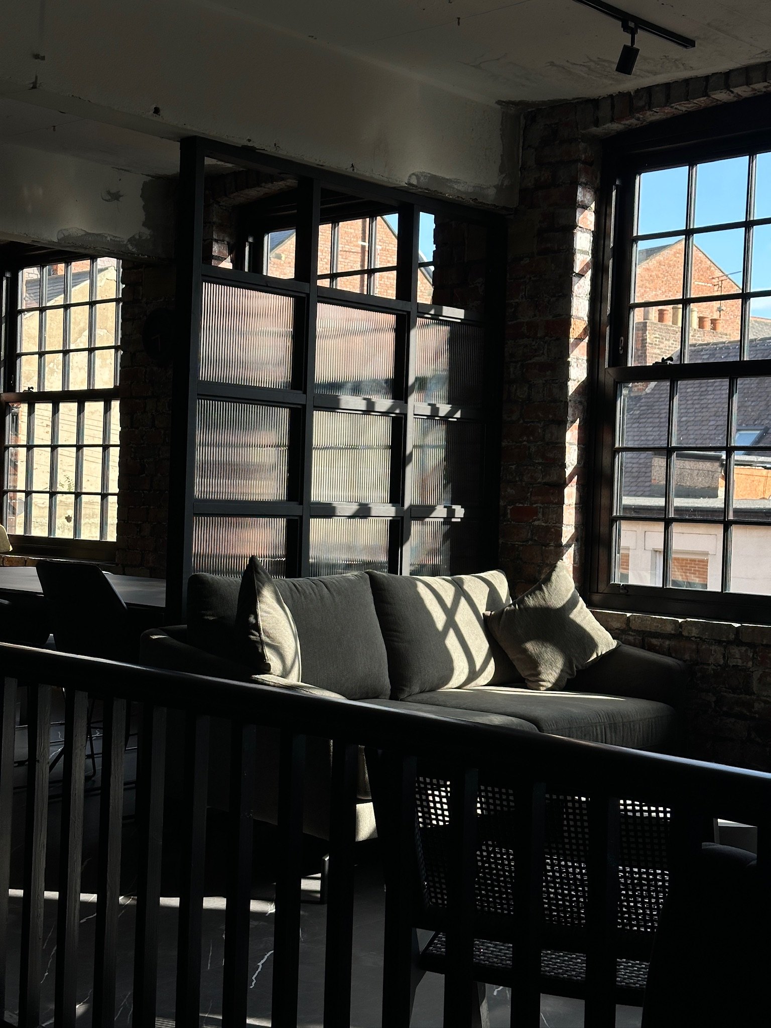Sunlit seating beside the industrial windows at Harbour House